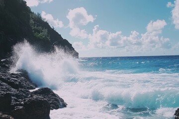 Obraz premium Panoramic view of waves crashing against rocks, capturing the beauty of nature's raw power, with a blue sky, white clouds, and a rocky shoreline.