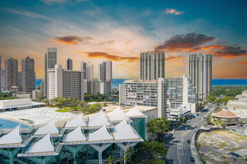 The Hawaii Convention Center with skyscrapers, hotels and luxury condos, lush green trees, ocean...