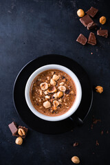 coffee with chocolate and hazelnuts in close-up on a black background