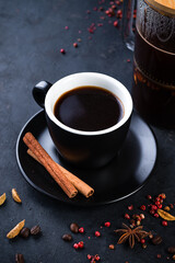coffee with anise, cinnamon and cardamom on a dark background