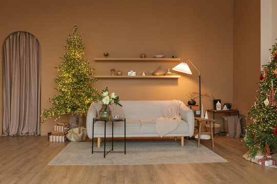 Two illuminated Christmas trees in a stylish Scandinavian style contemporary living room