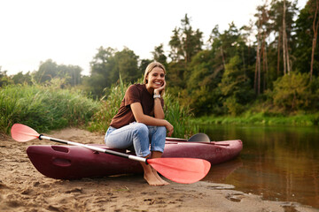 A Joyful Kayaker is Happily Enjoying the Breathtaking Beauty of Nature by the Picturesque River