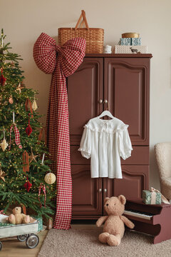 Blouse hanging on a wardrobe door in a festive bedroom with a Christmas tree and decorations