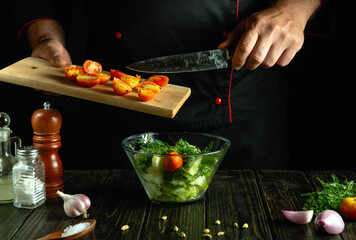 A talented chef prepares a colorful salad by carefully slicing ripe tomatoes while a bowl of mixed greens waits nearby, highlighting culinary art in a cozy kitchen environment