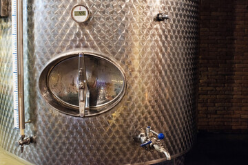 Stainless steel metal barrels for storing wine in a wine pub, cellar. Wine production equipment. Vinification technology