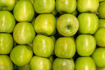 Green apples background. Ripe, juicy green apples on the counter at the grocery market, top view