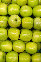 Green apples background. Ripe, juicy green apples on the counter at the grocery market, top view