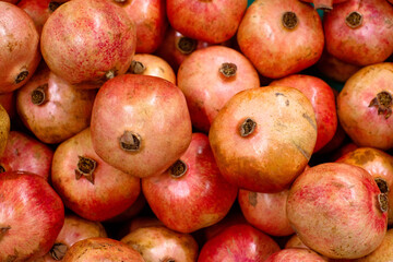 Ripe, juicy pomegranates on the counter at the food market. Background with pomegranates