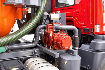 Industrial machinery with vibrant red equipment, focus on hydraulic pump details, representing...