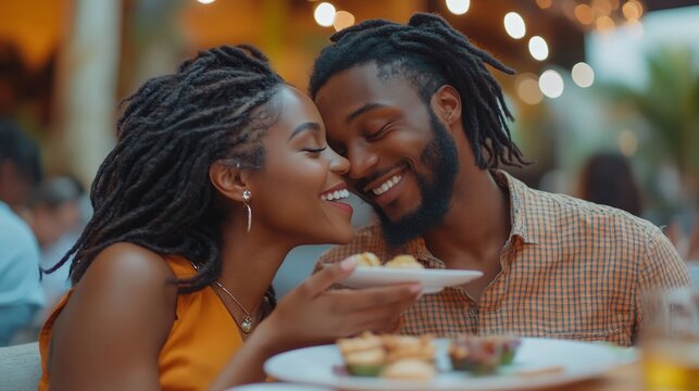 Happy couple sharing a meal and laughing together at a restaurant.