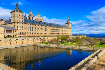 Beautiful El Escorial, or Royal Site of San Lorenzo de El Escorial, or Monasterio de El Escorial with garden and reflections in pond