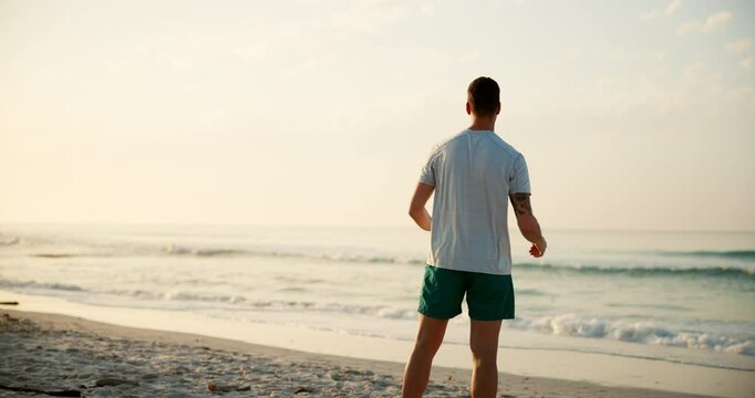 Man, fitness and stretching with back by ocean coast for breathing exercise, warm up or outdoor workout in nature. Male person, yogi or zen with sunset for balance, health and wellness on beach