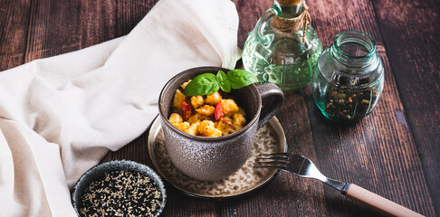 Bread pudding with egg, pepper and basil in a cup on the table web banner