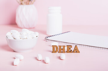 Hormonal supplement DHEA in tablets and a notebook on the table