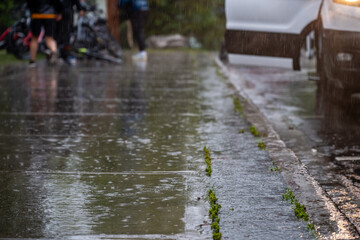 Fototapeta premium Sidewalk during a rain downpour with standing water