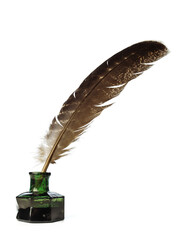 Feather in a green vintage inkwell. Quill pen with a glass bottle of ink