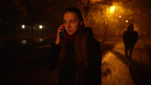 A frightened woman calls on the phone after noticing that she is being followed