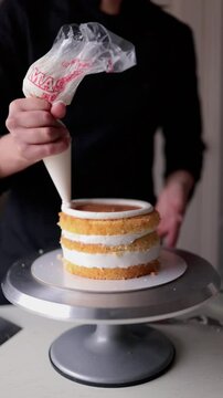 Woman pastry chef preparing cake with cream