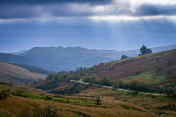 Storm clouds over Cribarth mountain and road through the Swansea Valley heading to Brecon town in South Wales
