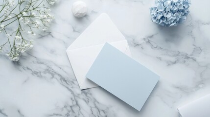 A blue card sits on a marble countertop with a white envelope next to it