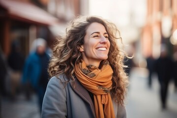 Portrait of beautiful young woman with curly hair walking in the city