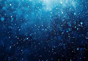 A blue snow background with defocused flakes of snow. Winter concept with falling snow. Holiday texture and white elements.