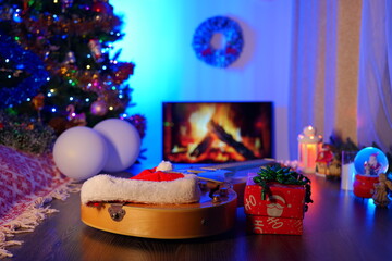 Electric Guitar by the Fireplace with a Christmas Tree and Ornaments. Cozy New Year and Christmas Scene Blending Music and Festive Holiday Decor.