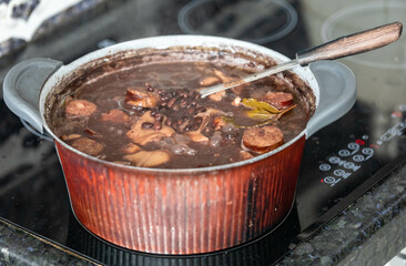 Traditional Brazilian feijoada in a rustic pan