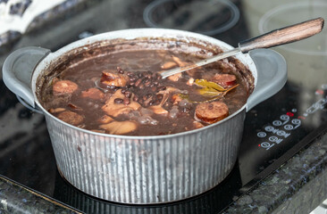 Traditional Brazilian feijoada in a rustic pan