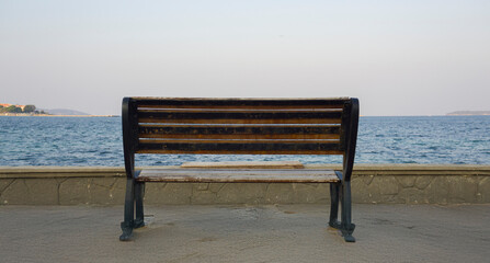 Empty bench facing the sea, symbolizing solitude and peaceful moments.