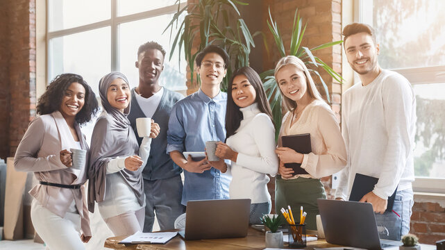 Portrait of young cheerful international business team posing together in office during working day - Powered by Adobe