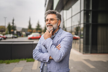 Portrait of senior man businessman arm crossed outdoor