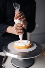 Close up of a woman decorating cake in the kitchen.