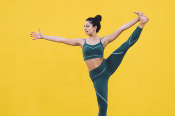 Obraz premium Young sporty slim woman exercising yoga revolved standing hand to toe pose using tablet in yard