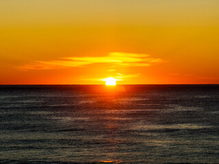 Sunrise at the seaside with clear skies and orange horizon