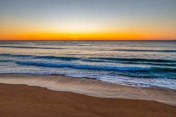 Sunrise at the seaside with clear skies and orange horizon