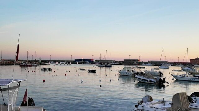 Sundown in the port of Anzio in Italy. Reflections in the water and vivid colors illuminate the scene with the boats moving. Located on the Tyrrhenian Sea dedicated to Sea dedicated to tourism