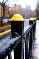 A black fence with a yellow post on it