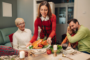 Happy family celebrating christmas eve having dinner together at home