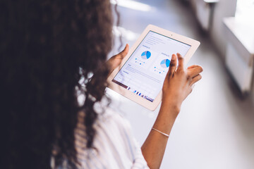 Professional office worker looking at diagrams on screen of tablet