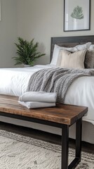 Cozy bedroom corner featuring a stylish nightstand with a folded blanket and decorative plant