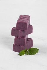 Dark blue grape candies. White gray background. Close-up