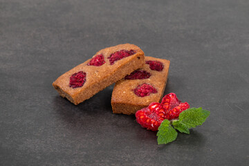 Vegan dessert. French cookie. Financier. Chocolate almond cookies with raspberries. Dark background. Close-up	