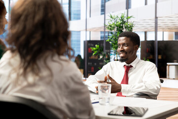 HR staff member implementing diversity recruitment strategy for startup business, talking with job candidate. Recruiter offering joyous african american man vacant company position