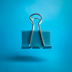 Binder clips floating or flying isolated on light blue background