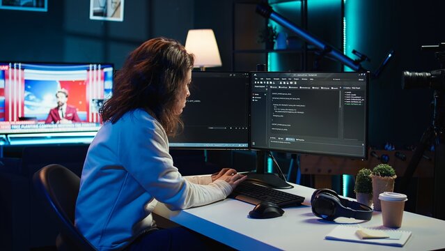 IT expert working from home developing software in JavaScript programming language using desktop PC. System engineer in living room writing lines of code on computer using keyboard, camera B