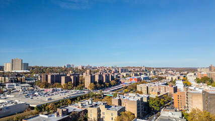 Obraz premium This location in the Bronx offers stunning views of lush greenery, a picturesque lake, and urban structures. Framed by the river, it showcases iconic bridges and the New York City skyline 