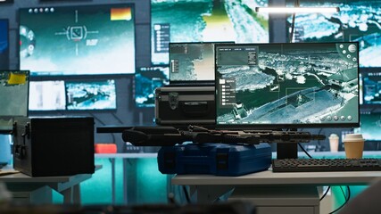 Weapons on table in secure room in army governmental facility operating as military command post and surveillance monitoring center. Extreme close up of guns in empty military base of operations