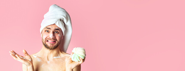 Shocked guy with towel on his head and in foam on pink background, copy space