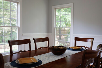 Dining Table With Wooden Chairs And Window View.